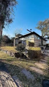 a house with a building in front of it at Hotel y cabañas FATVIAL 4 de Abril in Tanti