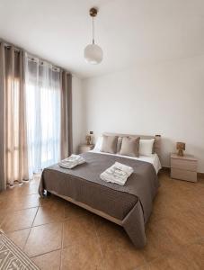 a bedroom with a large bed with two towels on it at Panorama Rooms in Gesualdo