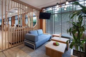 a living room with a blue couch and a table at Hotel Oliwski in Gdańsk