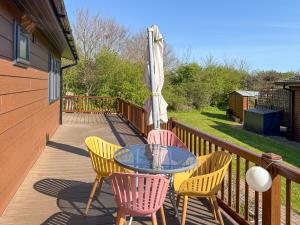a patio with a glass table and chairs and an umbrella at Staying Inn in West Mersea