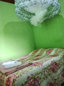 a bedroom with a bed with a dress hanging from the wall at Quarto Oliveira in Ibicoara