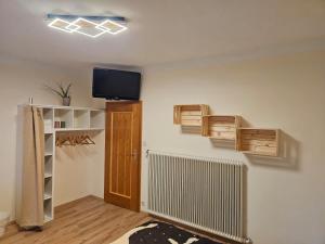 a room with a tv on a wall with wooden shelves at Ferienhaus Teichalm in Lantsch