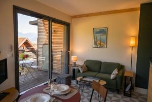 a living room with a couch and a table at Petit balcon du lac in Lathuile