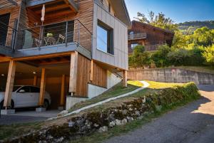 a house with a car parked in front of it at Petit balcon du lac in Lathuile