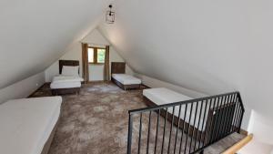 an attic room with two beds and a staircase at Echo Raduni in Stężyca
