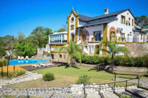 a large house with a pool in front of it at Hotel y cabañas FATVIAL 4 de Abril in Tanti