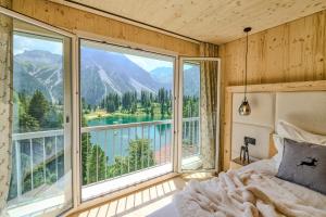 a bedroom with a bed and a large window at appartamaint tscherv by Arosa Vacations, Exklusive Wohnung im Zentrum mit Blick auf den Untersee und die Berge inkl Parkplatz in Arosa