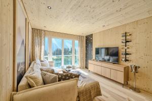 a living room with a couch and a television at appartamaint tscherv by Arosa Vacations, Exklusive Wohnung im Zentrum mit Blick auf den Untersee und die Berge inkl Parkplatz in Arosa