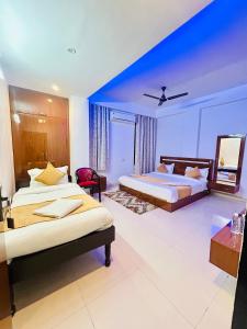 a bedroom with two beds and a blue wall at Hotel Veda Vatica in Varanasi