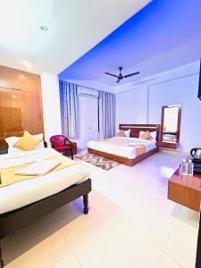a bedroom with two beds and a blue ceiling at Hotel Veda Vatica in Varanasi