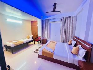 a bedroom with two beds and a window at Hotel Veda Vatica in Varanasi