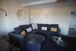 a living room with a blue couch and a table at Two Bed Flat Sea view Old town Hastings in Hastings