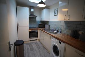 a kitchen with a washing machine and a sink at Two Bed Flat Sea view Old town Hastings in Hastings