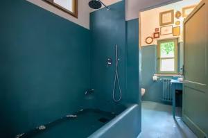 a blue bathroom with a tub and a shower at Capannacce Organic and Horse Farm in Rapolano Terme +60 photos