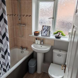 a bathroom with a sink and a toilet and a shower at Modern 2 bedroom house, sleeps 5 guests, Free parking in Hull +16 photos