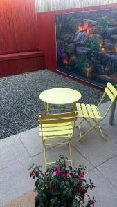 a yellow table and two chairs sitting next to a table and chairs at Modern 2 bedroom house, sleeps 5 guests, Free parking in Hull