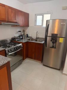 a kitchen with a stainless steel refrigerator and a sink at The Palace in San Isidro