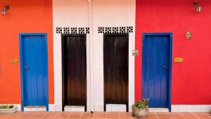 a building with three blue doors on it at Vila Santê in Belo Horizonte