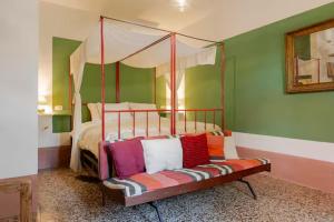 a bedroom with a bed and a couch with pillows at Capannacce Organic and Horse Farm in Rapolano Terme