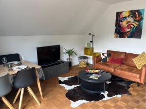 a living room with a couch and a table at Schorn³ Appartements in Zell an der Mosel