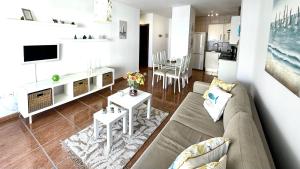 a living room with a couch and a table and a kitchen at 525 Aguamarina in San Miguel de Abona