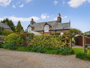 a house with a fence in front of a garden at Ivy Cottage in Crieff