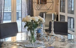 a glass table with a vase of white roses on it at Beautiful Apartment In Fredrikstad in Fredrikstad