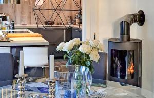 a kitchen with a fireplace and a table with flowers at Beautiful Apartment In Fredrikstad in Fredrikstad