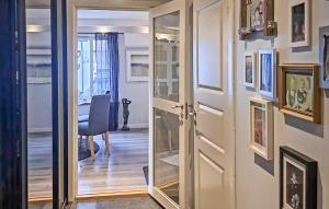 a hallway with an open door with a mirror at Beautiful Apartment In Fredrikstad in Fredrikstad +4 photos