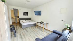 a room with a bed and a couch and a table at Cozy Studio Apartment In The Black Forest in Villingen-Schwenningen