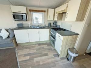 a small kitchen with white cabinets and a stove at Europa Caernarfon - Ukc9633 in Rowen