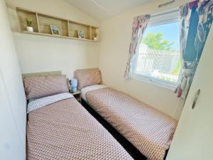 two beds in a small room with a window at Europa Caernarfon - Ukc9633 in Rowen