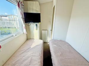 a small room with two beds and a window at Europa Caernarfon - Ukc9633 in Rowen