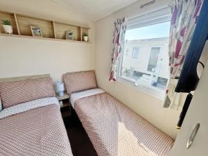 two beds in a small room with a window at Europa Caernarfon - Ukc9633 in Rowen +1 photo