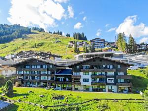 a large building with a grassy hill in the background at Haus am Anger Top 42 in Königsleiten +5 photos