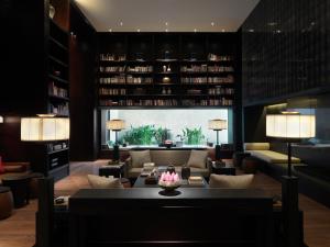a living room with a couch and a table and chairs at The Puli Hotel And Spa in Shanghai