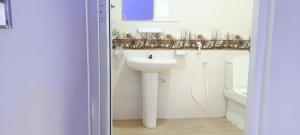 a white bathroom with a sink and a toilet at White House in Puttalam