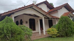 a small white house with a porch at White House in Puttalam +10 photos