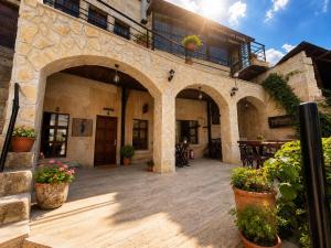 an outdoor patio with potted plants and a building at Cappadocia Cave House in Ürgüp