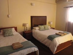 two beds in a bedroom with towels on them at Springbok Lodge & Restaurant in Springbok
