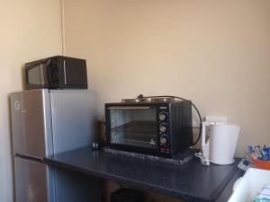 a microwave sitting on a counter next to a refrigerator at Springbok Lodge & Restaurant in Springbok