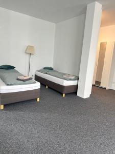 two beds sitting in a room with at Modernes Studio mit Küche, WLAN, Parkplatz in Dingolfing