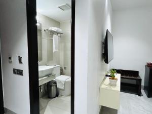 a white bathroom with a sink and a toilet at Royal Mark Hotel in Sylhet +26 photos