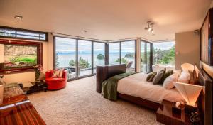 a bedroom with a bed with a view of the ocean at Lodge by the beach - Luxury, Beach access, Ocean views, Private chef in Kaiteriteri