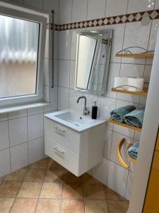 a bathroom with a white sink and a mirror at Ferienwohnung Weitblick in Rodalben