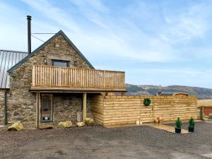 a wooden house with a deck on the side of it at Wellness Cottage At Tomnauld Farm in Pitlochry