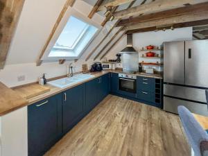 a kitchen with blue cabinets and a stainless steel refrigerator at Wellness Cottage At Tomnauld Farm in Pitlochry