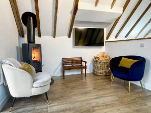 a living room with a chair and a stove at Wellness Cottage At Tomnauld Farm in Pitlochry