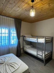 a bedroom with two bunk beds and a window at Family Nest in Shtoji i Ri