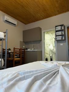 a bedroom with a white bed and a kitchen at Family Nest in Shtoji i Ri